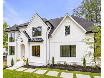 Stunning two-story white brick home with black accents and landscaped lawn at 1211 Stephens Se St, Smyrna, GA 30080