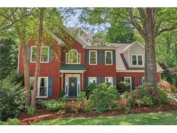 Charming two-story brick home with lush landscaping and a well-manicured lawn at 959 Cedar Falls Sw Ct, Lilburn, GA 30047