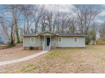 Charming single-story home with light green siding, a covered porch, and a well-manicured lawn at 2366 Forrest Park Se Rd, Atlanta, GA 30315