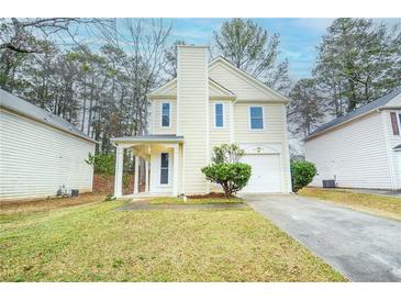 Charming home features a well-manicured lawn, inviting entryway, and attached garage at 5084 Brittany Dr, Stone Mountain, GA 30083