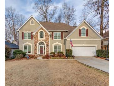 Charming two-story home featuring stone accents, red shutters, a two car garage and well-maintained landscaping at 1095 Whitehawk Trl, Lawrenceville, GA 30043