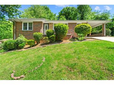 Brick ranch home with a spacious lawn and mature trees at 241 W Simon Nw Ter, Atlanta, GA 30318