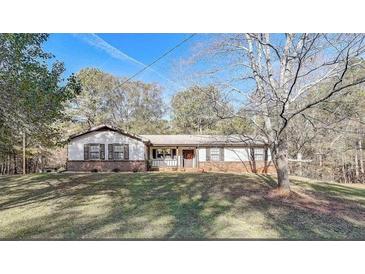 Ranch style home with brick accents and a spacious yard at 265 Forest Lakes Dr, Covington, GA 30016