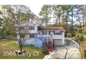 Charming two-story home featuring a spacious driveway, complemented by a well-maintained yard and a treed background at 3566 Carry Ct, Snellville, GA 30039