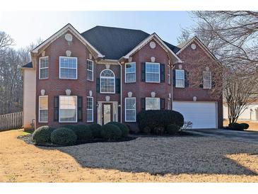 Brick two-story house with attached garage and manicured lawn at 1553 Rolling Meadows Dr, Mcdonough, GA 30253