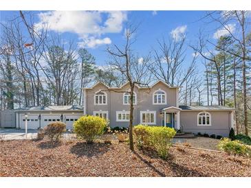 Two-story house with a three-car garage and manicured landscaping at 213 Pine Crest Dr, Cumming, GA 30040