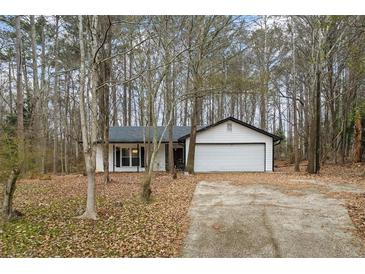 Ranch home with attached garage, nestled in a wooded lot at 7037 Shangrila Trl, Riverdale, GA 30296