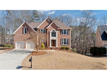 Charming brick home with two-car garage and well-maintained lawn and landscape at 5073 Kingsbridge Pass, Powder Springs, GA 30127