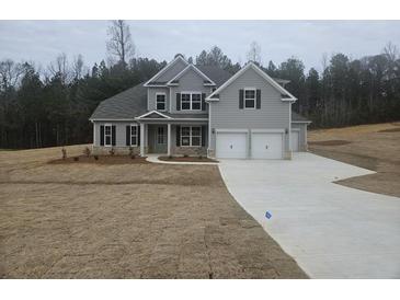 Beautiful two-story home with gray siding, a three-car garage, and a well-manicured lawn at 3292 Lions Ruby Ln, Atlanta, GA 30349