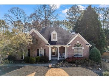 Charming brick home featuring a well-manicured lawn and inviting rocking chair front porch at 3377 Fielders Pt, Dacula, GA 30019