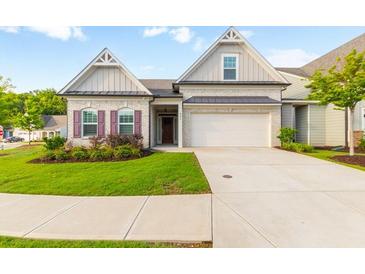 Brick home with 2-car garage, landscaping, and a welcoming front porch at 601 Cork St, Woodstock, GA 30188