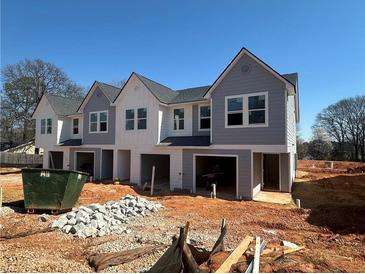 New townhome construction showcasing modern architectural design and unfinished landscaping at 11620 E Lovejoy Rd, Hampton, GA 30228