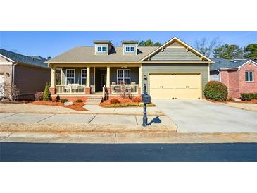 Charming craftsman home featuring a welcoming front porch, manicured lawn, and an attached two-car garage at 221 Aster Ct, Canton, GA 30114