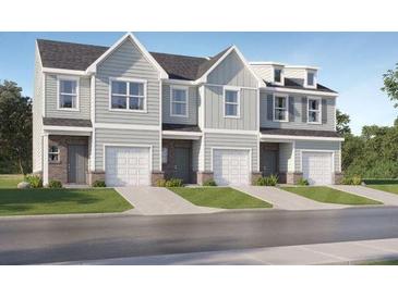 Three-unit townhome building with gray siding, white garage doors, and landscaping at 261 Kenoot Dr # 41, Mcdonough, GA 30253