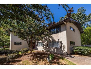 Charming exterior featuring a freshly painted brick facade and mature trees at 410 Candler Park Ne Dr # C-1, Atlanta, GA 30307