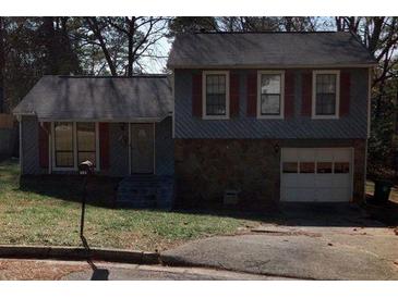 Ranch style home with attached garage and mature trees at 683 Wood Path Ct, Stone Mountain, GA 30083