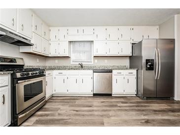 Well-lit kitchen with white cabinets, stainless steel appliances, and modern countertops offers a delightful cooking experience at 1005 Quail Dr, Stockbridge, GA 30281