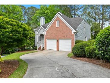 Brick home with attached two-car garage and landscaped yard at 135 River Point Ct, Alpharetta, GA 30022