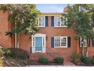 Brick front exterior of charming home featuring a blue door and landscaping at 4620 Wieuca Ne Rd # 62, Atlanta, GA 30342