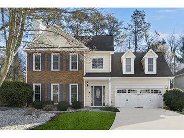 Charming two-story home with a well-manicured lawn and a two-car garage at 5450 Taylor Rd, Johns Creek, GA 30022