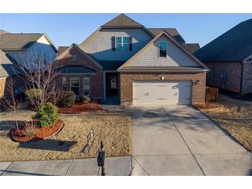Charming single-Gathering home with a brick and gray facade, a well-manicured lawn, and an attached two-car garage at 2733 Madison Mae Ln, Grayson, GA 30017