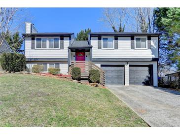 Charming two-story home featuring a well-manicured lawn and attached two-car garage at 1230 Worthington Hills Dr, Roswell, GA 30076