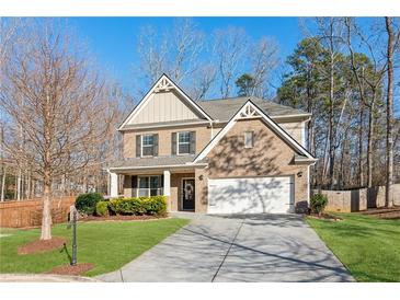 Two-story brick home with a front porch and attached two-car garage at 5750 Sutters Vw, Cumming, GA 30028