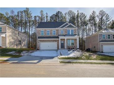 Two-story brick home with a white garage door and landscaping at 628 Leafy Branch Way, Mcdonough, GA 30253