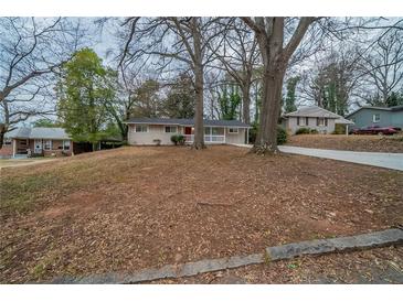 Charming ranch-style home with a red door and large front yard, ready for new landscaping at 2980 Laguna Dr, Decatur, GA 30032