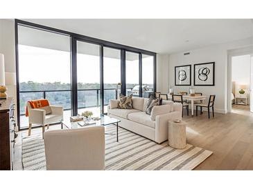 Bright living room with floor to ceiling windows, city views, and modern furniture at 2425 Peachtree Road # 1008, Atlanta, GA 30305