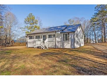 Newly renovated farmhouse features a front porch and large yard at 206 Hunters Ln, Powder Springs, GA 30127