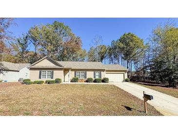 Charming one-story house with a landscaped lawn and attached garage at 607 Emma Way, Temple, GA 30179