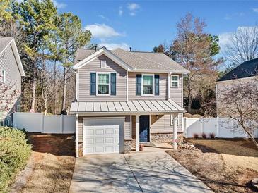 Two-story house with gray siding, white garage door, and a landscaped yard at 151 Nacoochee Way, Canton, GA 30114