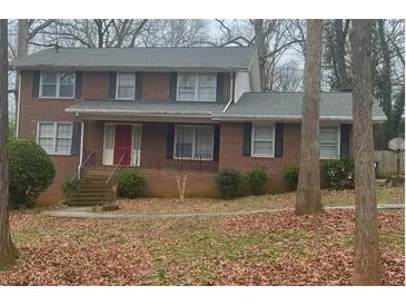 Brick house with gray roof, red door, and landscaping at 1971 Annette Ln, Austell, GA 30106