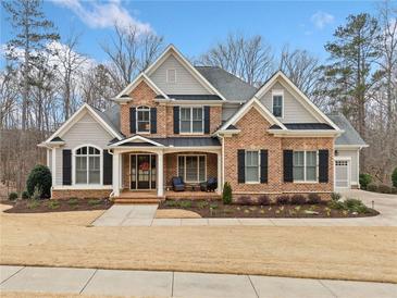 Charming brick home with black shutters, manicured lawn, and inviting front porch seating area at 2109 Rocky Falls Nw Ct, Kennesaw, GA 30152