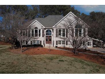 Two-story house with gray brick, dark shutters, and a large front yard at 409 E Point Dr, Canton, GA 30115