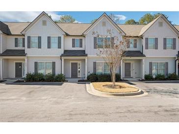 Three-unit townhome building, light gray siding, front entryways, and landscaping at 7744 Fawn Cir, Covington, GA 30014