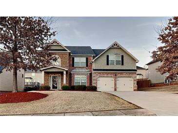 Two-story house with brick and siding, two-car garage, and landscaping at 876 Nevis Way, Mcdonough, GA 30253