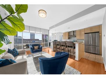 Bright, open-concept living area with hardwood floors, modern kitchen and large windows offering city views at 250 Park W Ave # 701, Atlanta, GA 30313