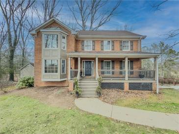 Brick house with wrap-around porch and landscaped yard at 3657 Linda Dr, Loganville, GA 30052