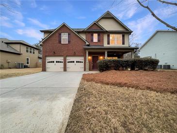 Brick two-story house with two-car garage and landscaped yard at 4444 Spring Mtn Ln, Powder Springs, GA 30127