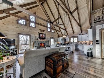 Stunning living room featuring wood-paneled walls, vaulted ceilings, and a stone fireplace at 255 Marks Way, Canton, GA 30115