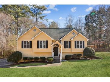 Inviting yellow house with a well-manicured lawn at 202 Mount Glen Ct, Woodstock, GA 30188