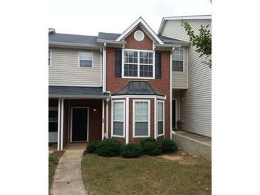 Charming brick townhouse with manicured bushes and inviting entrance at 125 Odyssey Turn, Conyers, GA 30012