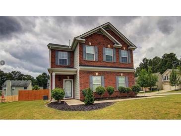 Brick two-story house with gray shutters, landscaping, and a manicured lawn at 7053 Creststone Way, Lithonia, GA 30038