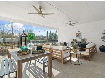 Inviting covered patio with ceiling fans and stylish outdoor furniture, perfect for relaxing and entertaining guests at 405 Nettle Ct, Woodstock, GA 30188