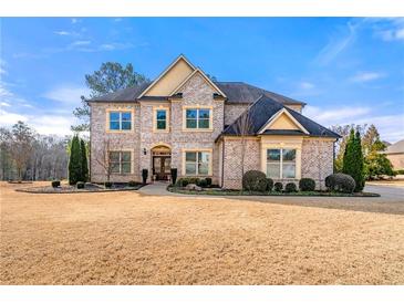 Two-story brick home with a large front yard and landscaping at 5269 Heron Bay Blvd, Locust Grove, GA 30248