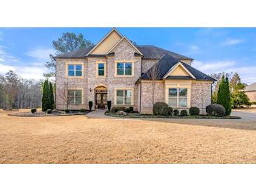 Stately brick home with manicured landscaping and mature trees creating a welcoming curb appeal at 5269 Heron Bay Blvd, Locust Grove, GA 30248