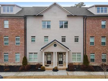 Brick front exterior of a charming townhome with a two-car garage at 1208 Stone Castle Cir # 3, Smyrna, GA 30080