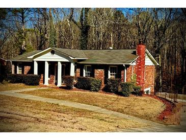 Brick ranch house with a large front yard and wooded backdrop at 4610 Spring Valley Pkwy, South Fulton, GA 30349